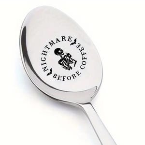May include: A silver spoon with a black design that says "Nightmare Before Coffee" with a skeleton holding a coffee cup and bats on either side.
