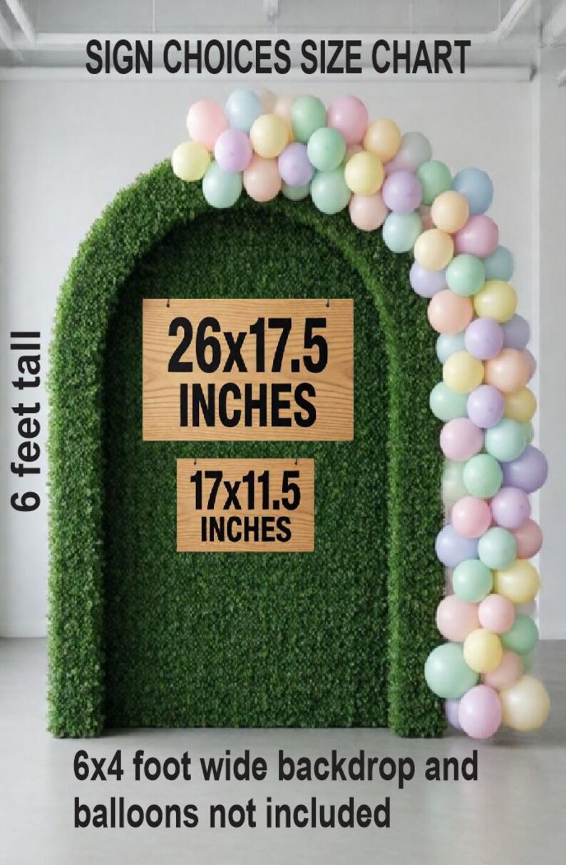 Op de afbeelding: Een groene boogvormige achtergrond met een pastelkleurige ballonslinger aan de rechterkant. Twee rechthoekige houten borden worden getoond, &eacute;&eacute;n met het label 26x17.5 INCHES en de andere 17x11.5 INCHES. Bovenaan staat SIGN CHOICES SIZE CHART.