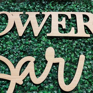 May include: Wooden sign with the words "Flower Bar" in cursive script. The sign is made of light brown wood and has a natural wood grain finish.