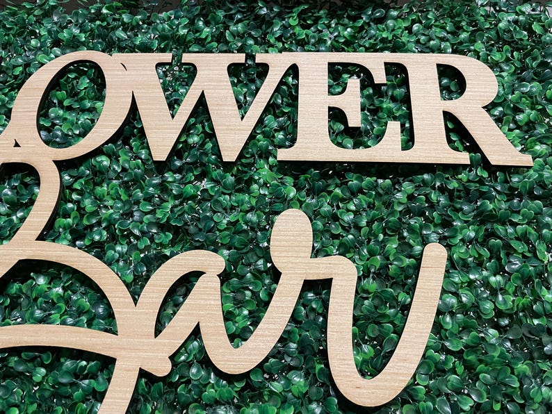 May include: Wooden sign with the words "Flower Bar" in cursive script. The sign is made of light brown wood and has a natural wood grain finish.