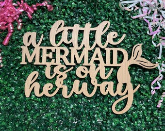 Letrero de fondo para baby shower con texto "La Sirenita está en camino"