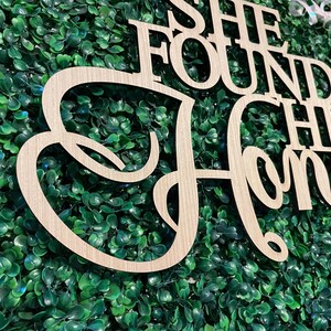 Peut inclure: Panneau en bois avec l'inscription "She Found Her Honey" dans une police cursive. Le panneau est en bois de couleur claire et est plac&eacute; sur un fond de feuillage vert. Id&eacute;al pour la d&eacute;coration de mariage ou de fian&ccedil;ailles.