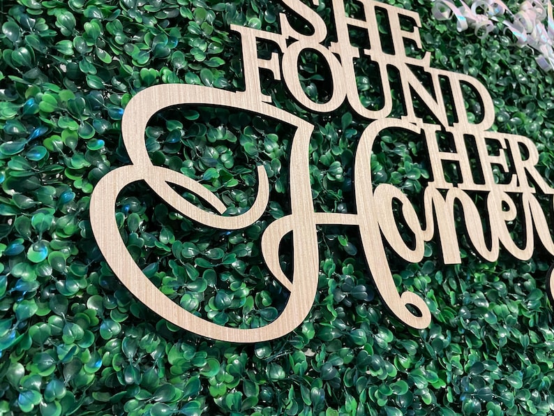 Peut inclure: Panneau en bois avec l'inscription "She Found Her Honey" dans une police cursive. Le panneau est en bois de couleur claire et est plac&eacute; sur un fond de feuillage vert. Id&eacute;al pour la d&eacute;coration de mariage ou de fian&ccedil;ailles.
