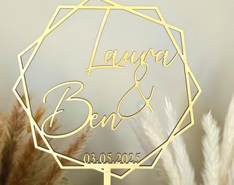 May include: Gold geometric cake topper with the names Laura & Ben and the date 03.05.2025.