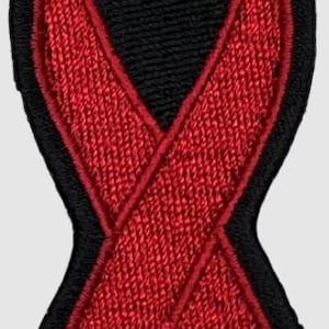 Op de afbeelding: Gestikt patch in de vorm van een rood lint met een zwarte omtrek.