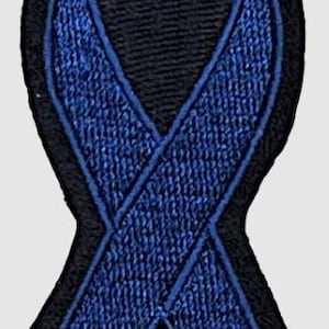Puede incluir: Parche bordado de cinta azul con contorno negro. La cinta es un símbolo de apoyo y concienciación.