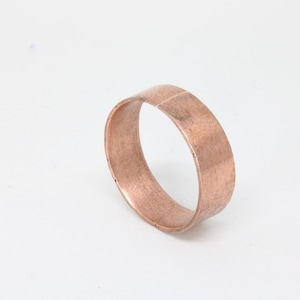 May include: A copper ring with a hammered finish.