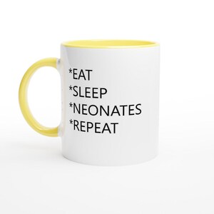 Puede incluir: Taza de cerámica blanca con borde amarillo. La taza tiene texto negro que dice "*EAT *SLEEP *NEONATES *REPEAT"