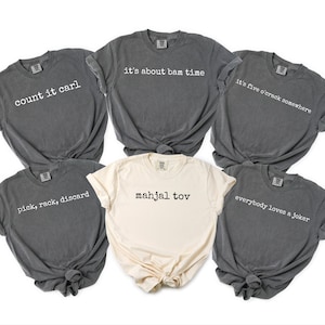 a collection of six gray t-shirts with various phrases printed on them, arranged in a circular pattern.