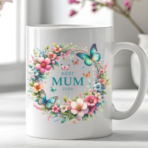 May include: White ceramic mug with a floral wreath design featuring butterflies and the text "Best Mum Ever".