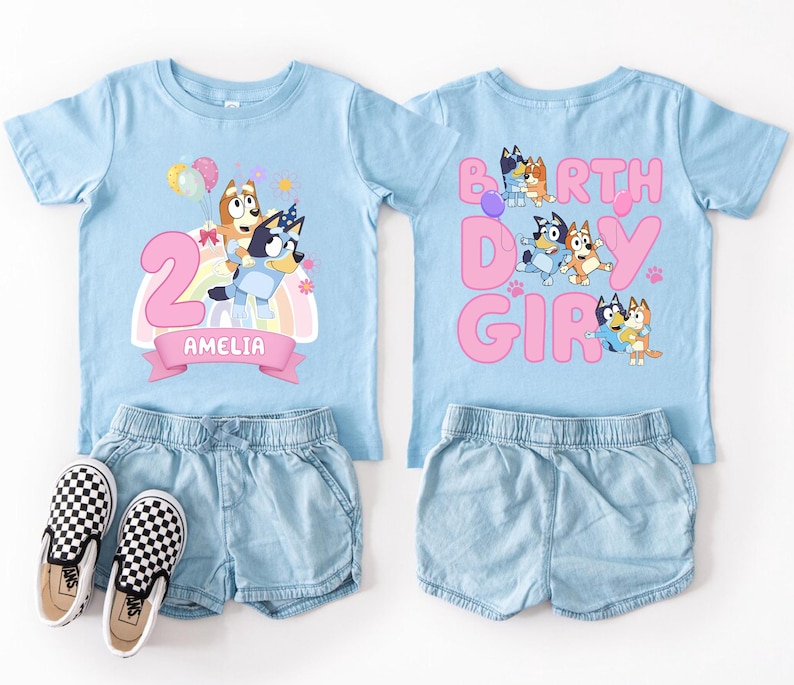 A pair of blue t-shirts with cartoon character designs and the text "Amelia" printed on them, along with denim shorts and checkered shoes.