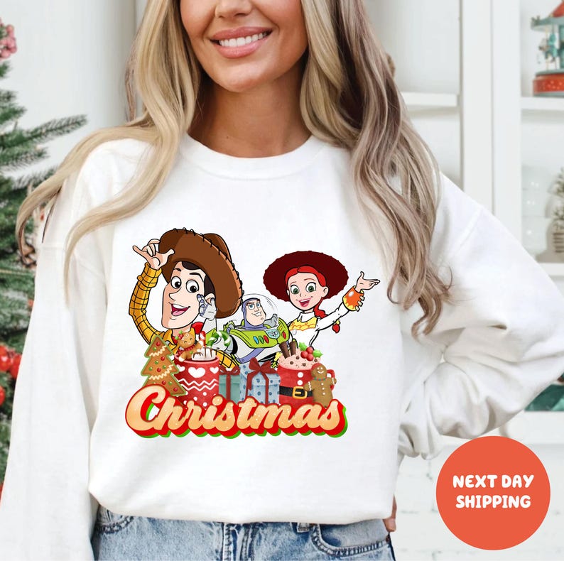 A woman wearing a white sweater with a Christmas-themed graphic design featuring characters from the Toy Story franchise.