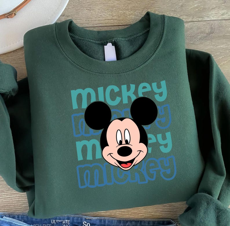 A green sweatshirt with a Mickey Mouse graphic printed on it.