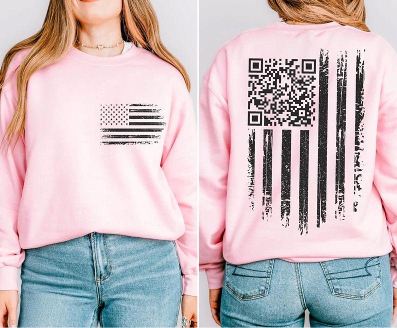 A woman wearing a pink sweatshirt with an American flag design and a QR code on the back.