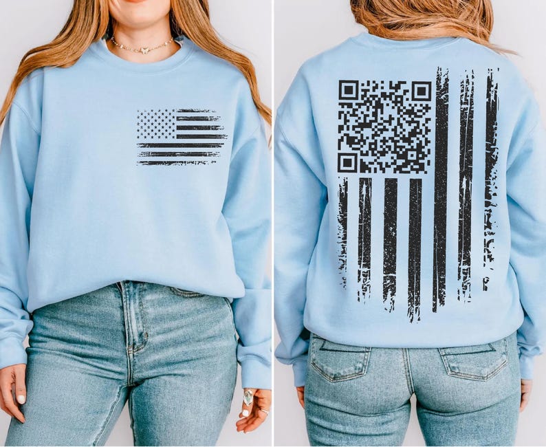 A woman wearing a light blue sweatshirt with an American flag design and a QR code printed on the back.