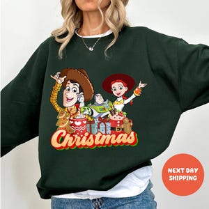 A woman wearing a green sweater with a Christmas-themed graphic of characters from the Toy Story movie.