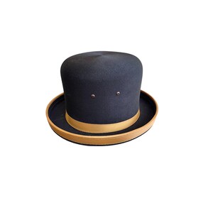 May include: A black felt bowler hat with a brown leather band.