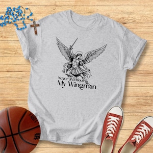 May include: A light grey t-shirt with a black and white angel illustration, holding a sword, with the text "Never Without My Wingman". Red trainers and a basketball are also visible in the image.
