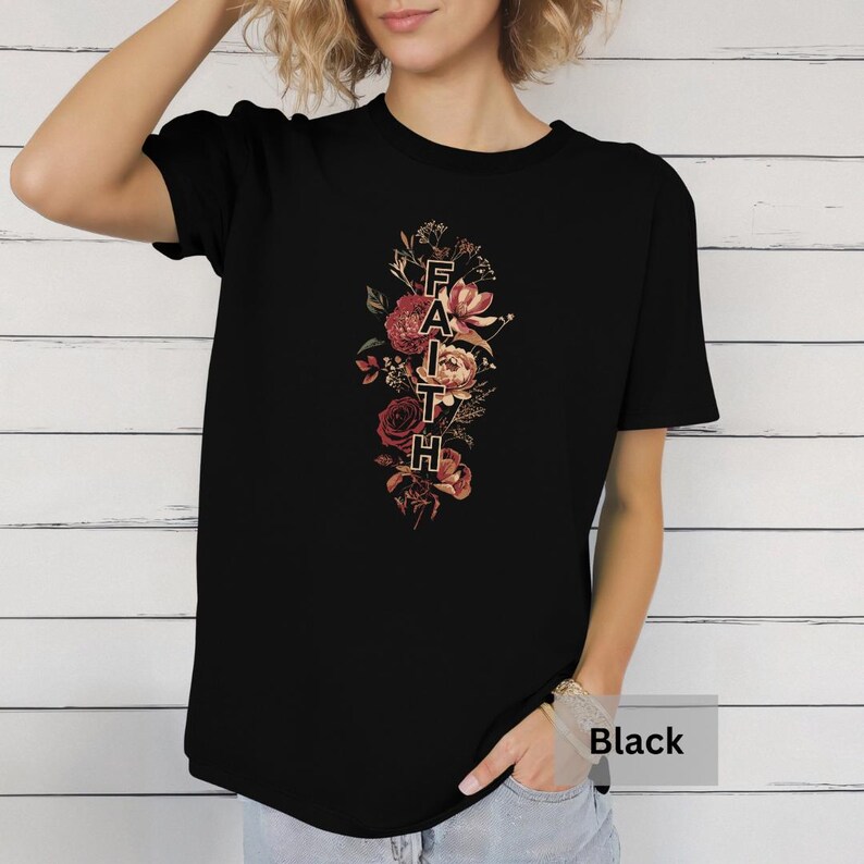 May include: Black t-shirt with a floral design and the word "FAITH" spelled vertically in the center of the design.