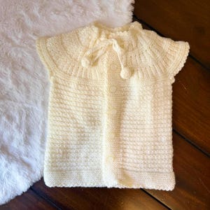 Handmade Ivory Knit Baby Cardigan with Button Closure and Pom-Pom Ties - Soft and Cozy Baby Gift