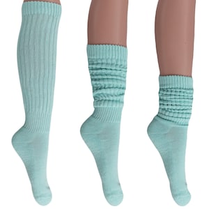 May include: Three pairs of light turquoise socks are displayed. One pair is knee-high with vertical ribbing, while the other two pairs are slouch socks with a ribbed cuff and a scrunched design. The socks are made of a soft, knitted material.