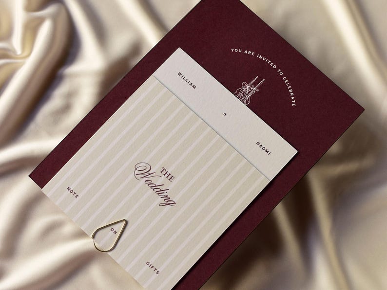 May include: A wedding invitation suite featuring a burgundy card with the text "YOU ARE INVITED TO CELEBRATE". The invitation card has a cream and white striped pattern with the words "THE Wedding" and the names "William & Naomi". A gold paper clip is attached.