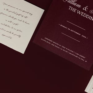 May include: A wedding invitation suite featuring a burgundy invitation card with white text, including the names "William & Naomi" and the date "Monday 09 September 2026." A separate card includes a message about gifts. A striped card is also visible.