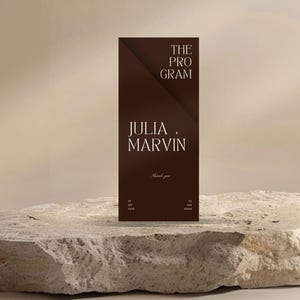 Peut inclure: Une carte rectangulaire marron foncé avec le texte "THE PROGRAM" et "JULIA . MARVIN" en blanc. La carte est posée sur une surface en pierre rugueuse et claire, sur un fond neutre. Les mots "Thank you" sont également visibles.
