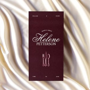 May include: A burgundy invitation card with the names William and Naomi at the top. The card reads "Have a seat Helene Petterson" in elegant script, with a fork, knife, and spoon illustration. The bottom reads "Time to dine."