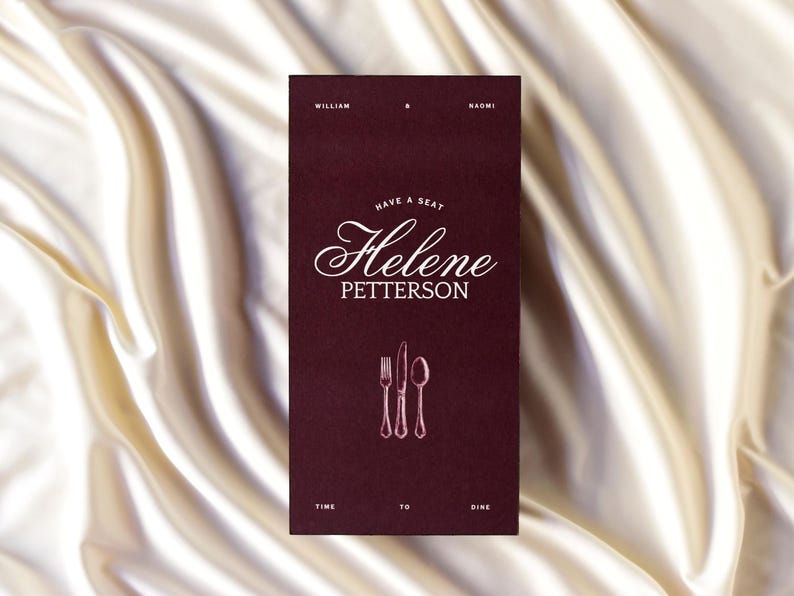 May include: A burgundy invitation card with the names William and Naomi at the top. The card reads "Have a seat Helene Petterson" in elegant script, with a fork, knife, and spoon illustration. The bottom reads "Time to dine."