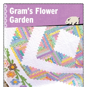 May include: A handmade quilt with the text "Gram's Flower Garden." The quilt features a white background with colorful, geometric patterns and floral appliqués along the edges. The quilt is made by Pink Hippo Quilts.