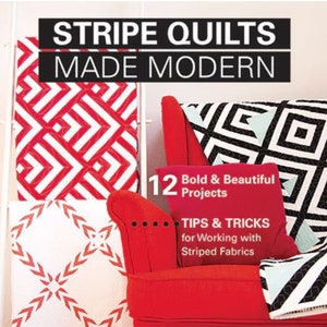 May include: A book cover with the title "Stripe Quilts Made Modern" featuring a red and white striped quilt on a red armchair with a black and white striped pillow. The book cover also includes the text "12 Bold & Beautiful Projects" and "Tips & Tricks for Working with Striped Fabrics".