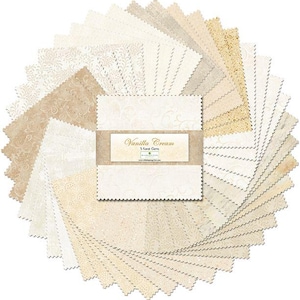 May include: A circular arrangement of fabric squares in various shades of cream and beige. The squares have different patterns, including floral and textured designs. A rectangular label in the center reads "Vanilla Cream" in gold script.