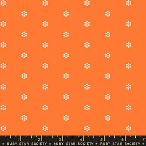 May include: Orange fabric with a repeating pattern of white flowers. The fabric is marked with a ruler and the text "RUBY STAR SOCIETY".
