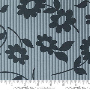 May include: Fabric with a repeating floral pattern. Dark gray flowers and leaves are set against a light blue and gray striped background. The fabric has a ruler along the bottom edge, with the word "moda" printed on it.