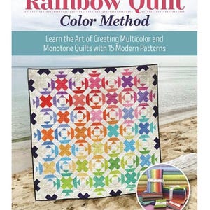 May include: A colorful quilt with a geometric pattern, displayed on a sandy beach. The quilt features a rainbow color scheme and is the focal point of the image. The book cover reads "Rainbow Quilt Color Method" and "Learn the Art of Creating Multicolor and Monotone Quilts with 15 Modern Patterns."