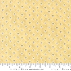 May include: Yellow fabric with a repeating pattern of small, light purple and green floral designs. The background has a dotted grid pattern. The fabric is marked with a ruler along the bottom edge. The text "moda fabrics" and "www.modafabrics.com" are visible.