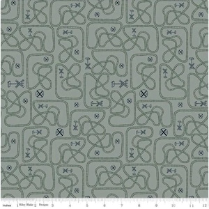 Puede incluir: Una tela verde con un patrón repetido de vías de tren y señales de cruce de ferrocarril. La tela está diseñada para acolchar y manualidades.