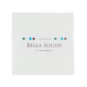 May include: A stack of white fabric squares with a scalloped edge, wrapped with a white band. The band features the text "BELLA SOLIDS" in brown, with the brand name "moda" above and below. Small colored dots in green, blue, and brown are also present.
