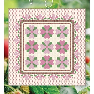 Puede incluir: Un patrón de colcha llamado "Raspberry Patch" con un diseño floral rosa y verde. El patrón está rodeado por un borde de flores rosas y blancas. La colcha está hecha por Pink Hippo Quilts.