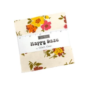 May include: A stack of fabric squares with a floral pattern in yellow, orange, and pink on a cream background. The fabric is wrapped with a white band that reads "Happy Daze by Chloe's Closet."