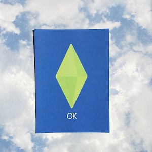 May include: A rectangular blue print featuring a lime green diamond-shaped plumbob icon centered in the middle. Below the green diamond, the word OK is printed in a simple white sans-serif font. The design is presented against a cloudy sky background.