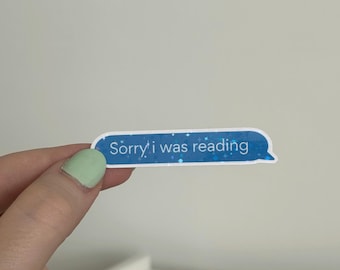 Può includere: Un adesivo a forma di fumetto con le parole "Sorry i was reading" in testo bianco su sfondo blu. L'adesivo ha un effetto glitterato.
