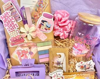 May include: A gift box containing a glass tumbler with a bamboo lid, a purple hair claw clip, pink scrunchie, gold-tone book necklace, crystal collagen eye masks, reading log, sticky notes, and various book-themed stickers and accessories.