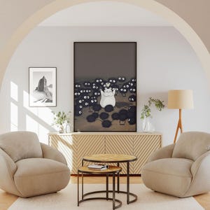May include: A living room scene featuring two beige armchairs, a wooden cabinet, and two round coffee tables. A large framed print depicts a white cartoon character surrounded by black soot sprites. A smaller framed print shows a black and white landscape.