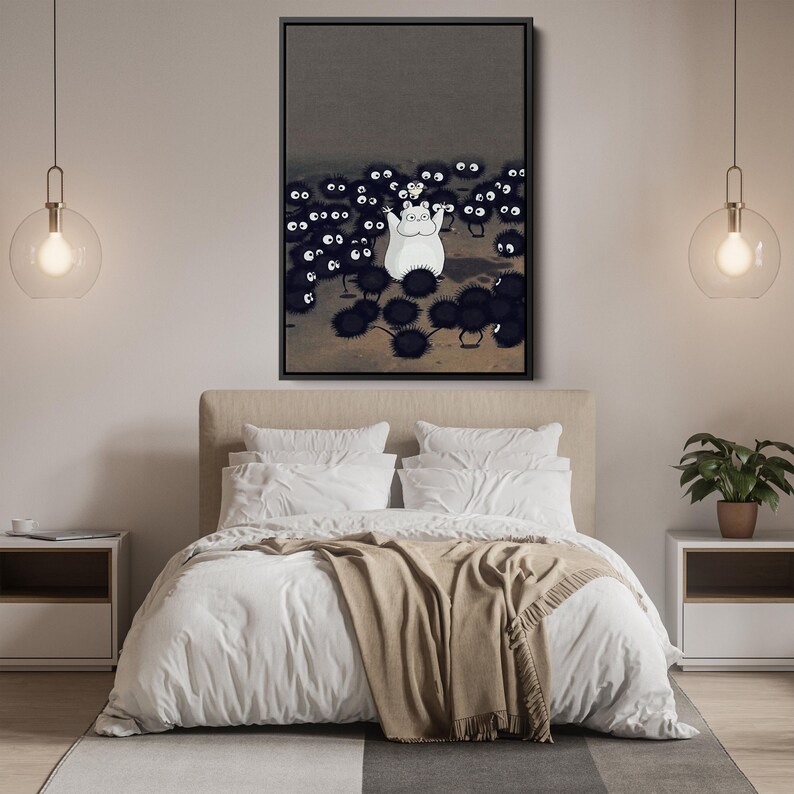 May include: A framed art print featuring a white cartoon character surrounded by many black, spiky creatures with large eyes. The artwork is set against a dark gray background. The print is displayed above a bed with white bedding and a tan throw.
