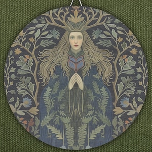 May include: Round wall art featuring a woman with long, flowing hair and a crown of antlers. The woman is wearing a blue robe and surrounded by a detailed floral and tree design in shades of green, blue, and brown. The artwork has a vintage, folk art style.