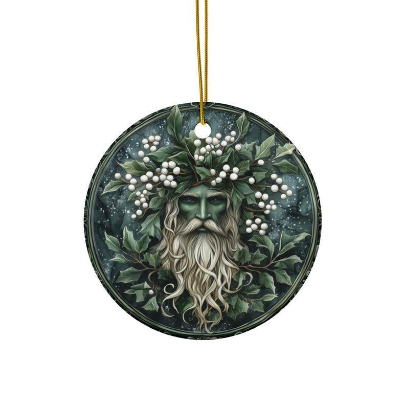 May include: A round ceramic ornament featuring a green-skinned man with a long white beard and a crown of white berries and green leaves. The background is a dark blue with white speckles.