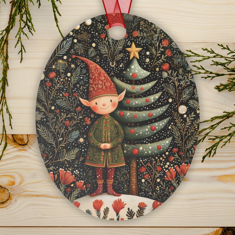 May include: Oval Christmas ornament featuring a whimsical elf in a green coat and red hat, standing next to a decorated Christmas tree. The background is a dark floral pattern with red accents, and a red ribbon is attached for hanging.