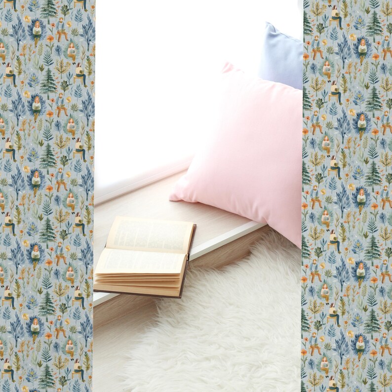 Puede incluir: Una almohada rosa claro y una almohada azul est&aacute;n en un asiento de ventana con un libro abierto en el asiento. El asiento de la ventana est&aacute; cubierto con una alfombra de piel sint&eacute;tica blanca. La pared detr&aacute;s de las almohadas est&aacute; cubierta con un papel tapiz azul y verde con un patr&oacute;n repetitivo de personas leyendo en un bosque.